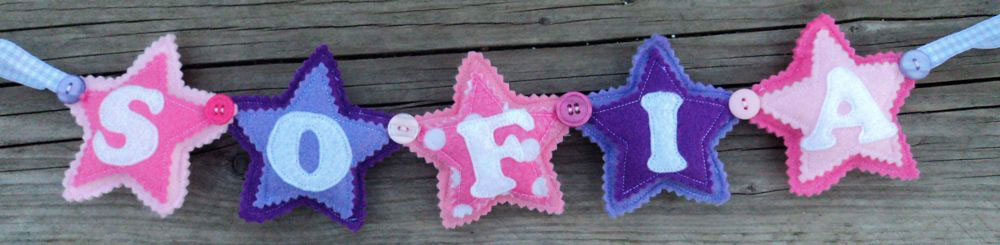 Butterfly Name Banner- in pink, lilac and white. £16 for up to three letters (this includes the butterfly’s at either end, so the two butterfly’s plus three letters). £2 for each additional letter. This one is priced at £22. Each of the letters are 4½ inches tall — the length of the banner will depend on the letters used (as some letters are wider than others) and the number of letters required. These can be done in any combination of colours. Star Name Banner in Pinks / Purple. £12 for up to four letters, each additional letter is £2. This one is priced at £14. Each shape is 3½ inches tall and usually the same width. These can be done in any combination of colours.